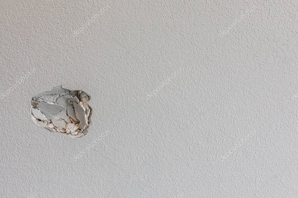 Hallway wall with dents and gouges before drywall patching