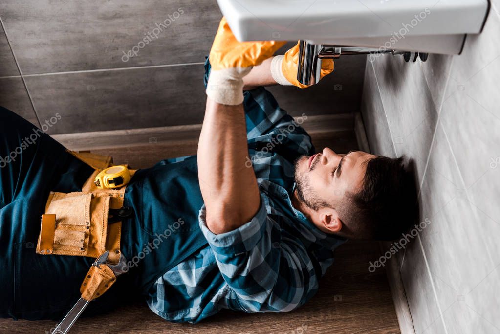 Under-sink plumbing after leak repair with new fittings and dry cabinet